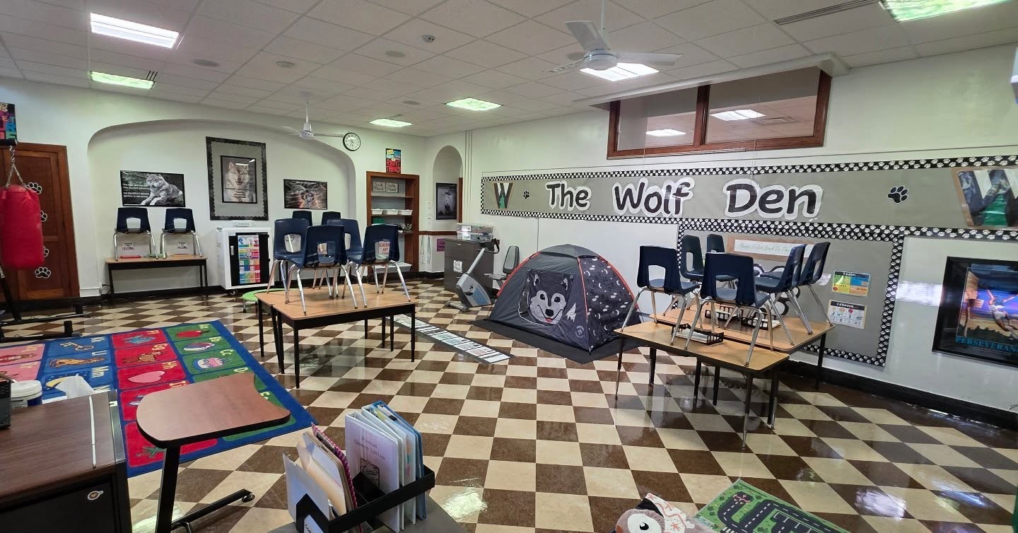 Classroom photo with chairs and "Wolf Den" wall art